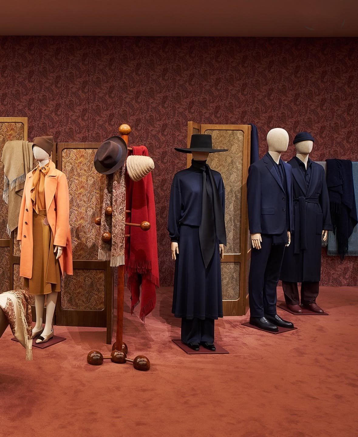 A Dior exhibition, dresses on mannequins under blue light