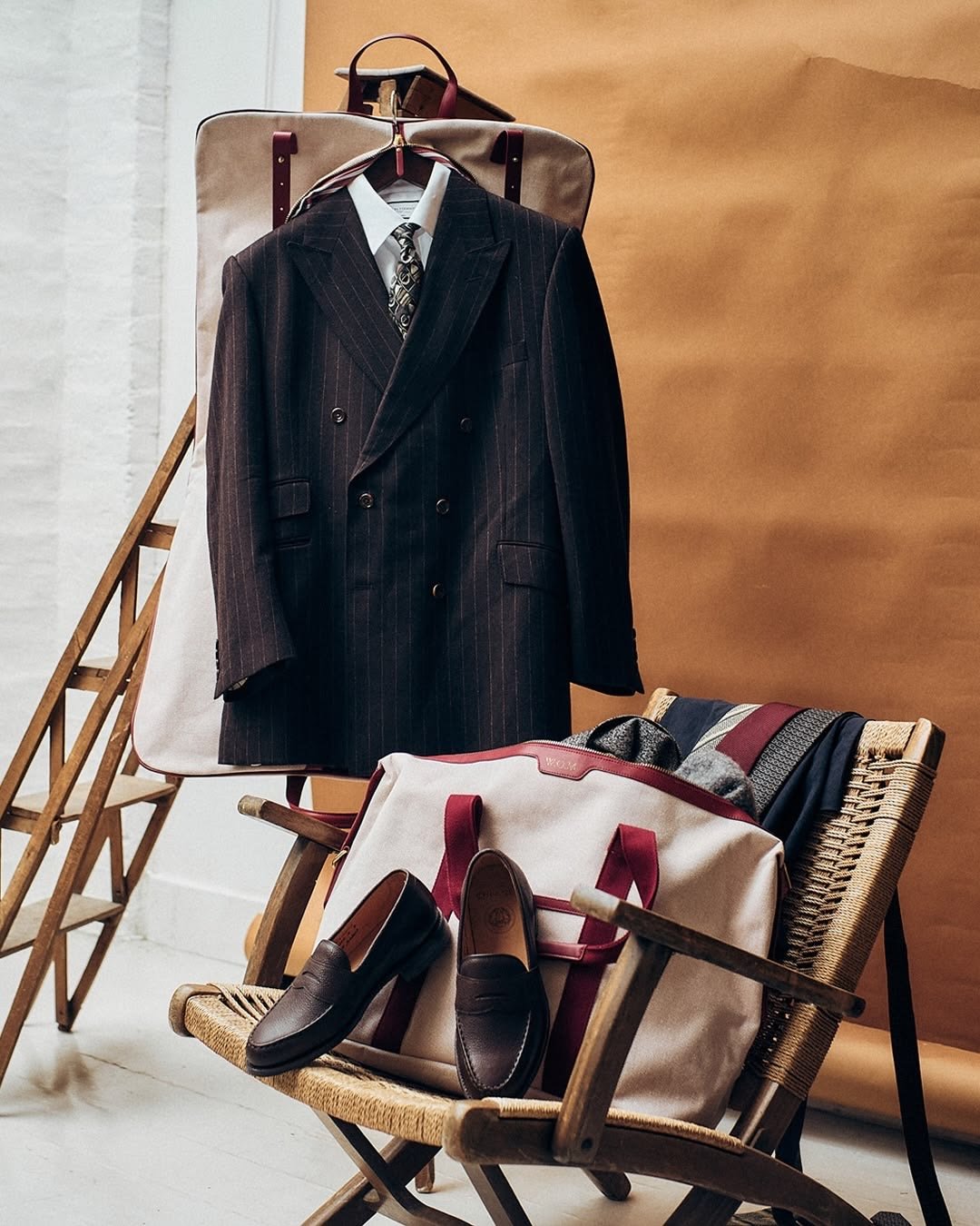Neutral knitwear and trousers hanging on white clothes rails