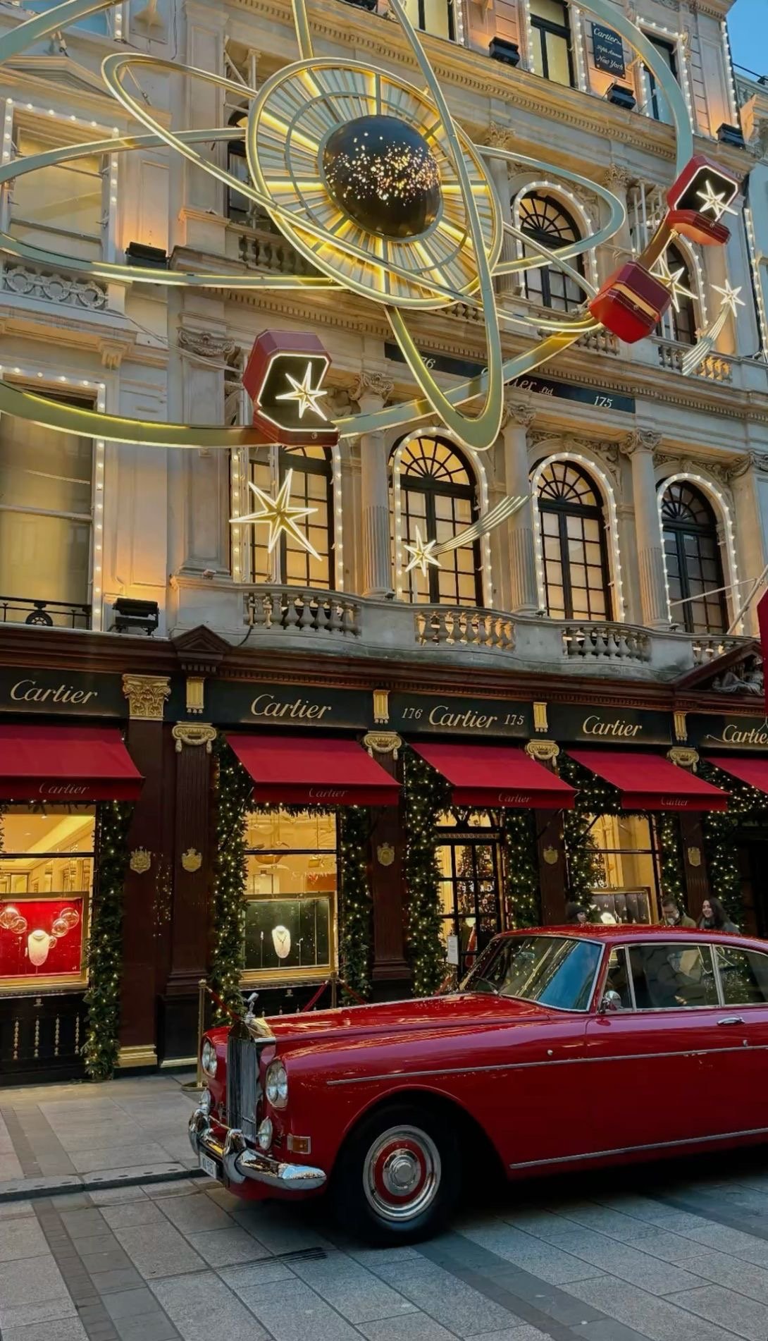 Regent Street's Christmas angels lit above shoppers and a red London bus